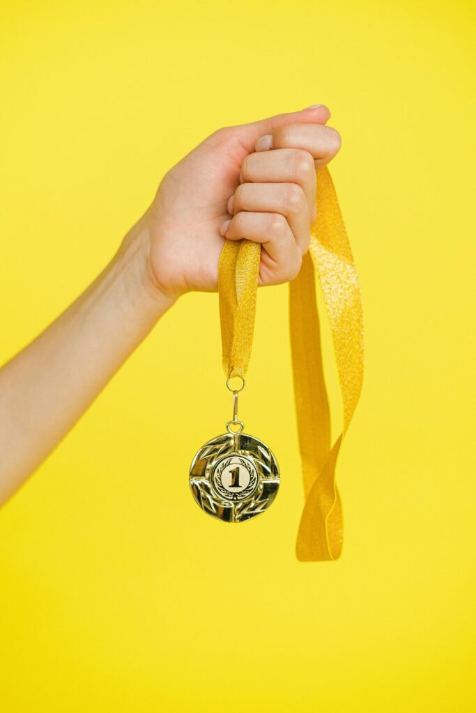 Person Holding a Gold Medal